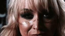 a close up of a woman 's face with a tattoo on her face