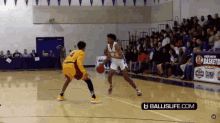 a basketball game is being played on a court with a banner for ballislife.com in the background