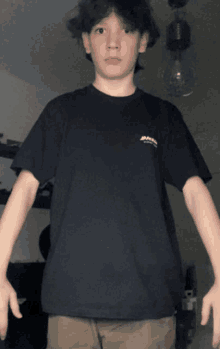 a young boy wearing a black t-shirt that says dickies on it