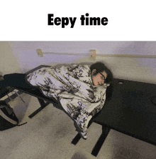 a person wrapped in a blanket laying on a desk with the words eepy time below them