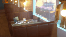 a diner booth with a laptop and a cup of coffee on it