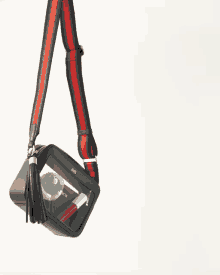 a black purse with a red and green strap and a clear item inside