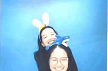 two women wearing bunny ears and a stuffed shark headband