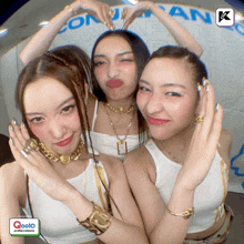 three women are posing for a picture with a logo that says q0010 on it