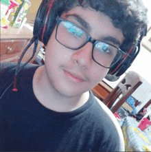 a young man wearing glasses and headphones looks at the camera and smiles