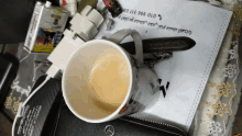 a cup of coffee sits on a table next to a piece of paper with arabic writing