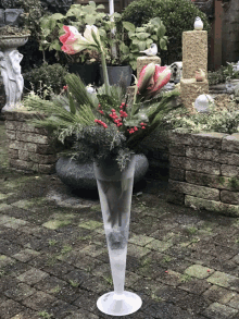 a tall vase filled with flowers and berries