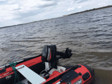 a red boat with a mercury outboard motor on the back