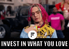 a man with pink dreadlocks is pointing at something with the words invest in what you love written below him