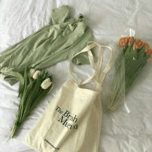 a tote bag from the brish museum sits on a bed next to flowers