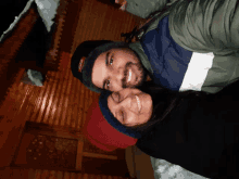 a man and a woman are posing for a picture in front of a wooden house