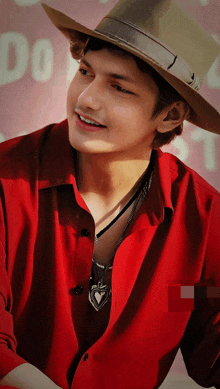 a young man wearing a hat and a red shirt