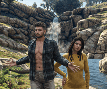 a man in a plaid shirt stands next to a woman in a yellow dress in front of a waterfall