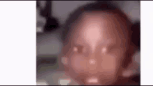 a close up of a baby 's face with a blurred background .