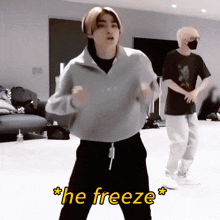 a man in a grey sweater is dancing with the words " he freeze " written above him