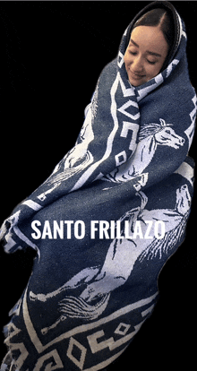 a woman wrapped in a blanket that says santo friillazo