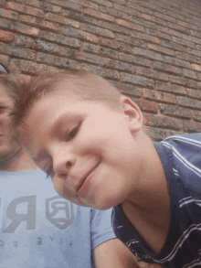 a boy wearing a blue shirt that says " evil " on it