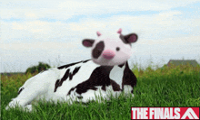 a stuffed cow is laying in the grass with the finals written on the bottom