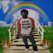 a man wearing a shirt that says lead never follow is standing on stairs