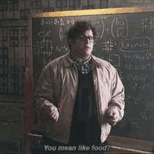 a man standing in front of a blackboard with the words " you mean like food " written on it