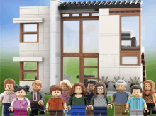 a lego family poses in front of a house