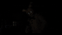 a yellow bunny with a blue bow tie is in a dark room