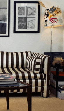 a black and white striped couch is in a living room with a poster on the wall that says miller