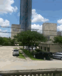 a white truck is parked in a parking lot in front of a building that says ' houston financial center ' on it