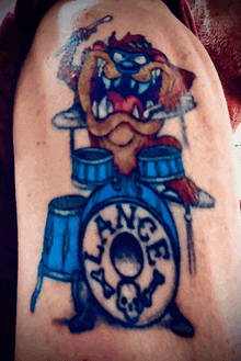 a person has a tattoo of a cartoon character playing drums