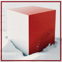 a red and white cube in the snow with a red border