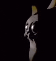 a close up of a person 's face in the dark with their eyes glowing .