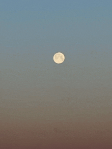 a full moon is visible in a clear sky