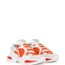 a pair of white and orange sneakers with a zipper on the side on a white background .