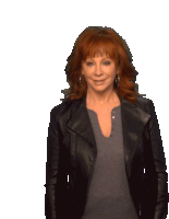 a woman with red hair is wearing a black leather jacket and a grey shirt