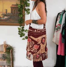 a woman is standing in front of a painting of a boat