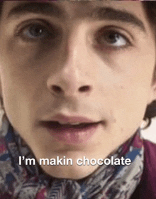 a close up of a young man 's face with the words `` i 'm makin chocolate '' written on it .