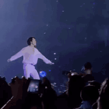 a man is dancing on stage in front of a crowd .