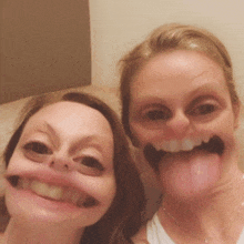 two women make funny faces with their tongues sticking out