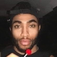 a man with a beard is eating a lollipop in a car .