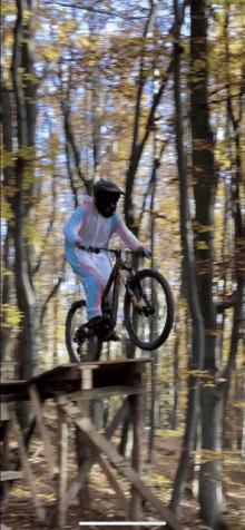 a person on a bike jumping over a wooden platform