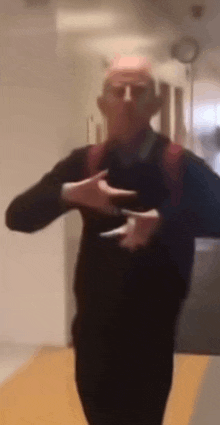 a blurry picture of a man dancing in a hallway with his hands outstretched .