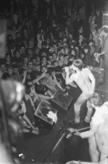 a man singing into a microphone in front of a large crowd