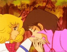 a boy and a girl are kissing each other on the cheek .