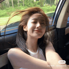 a woman sitting in a car with her hair blowing