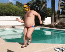 a shirtless man in a spongebob mask is dancing by a pool .