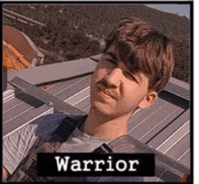 a young man is sitting on a roof with a sign that says warrior above him .