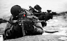 a man with a rifle with a red dot sight on it