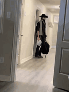 a man in a cowboy hat is walking in a hallway