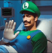 a man is laying in a hospital bed dressed as luigi from super mario bros .