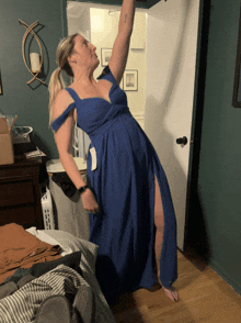 a woman in a blue dress is standing on a bed